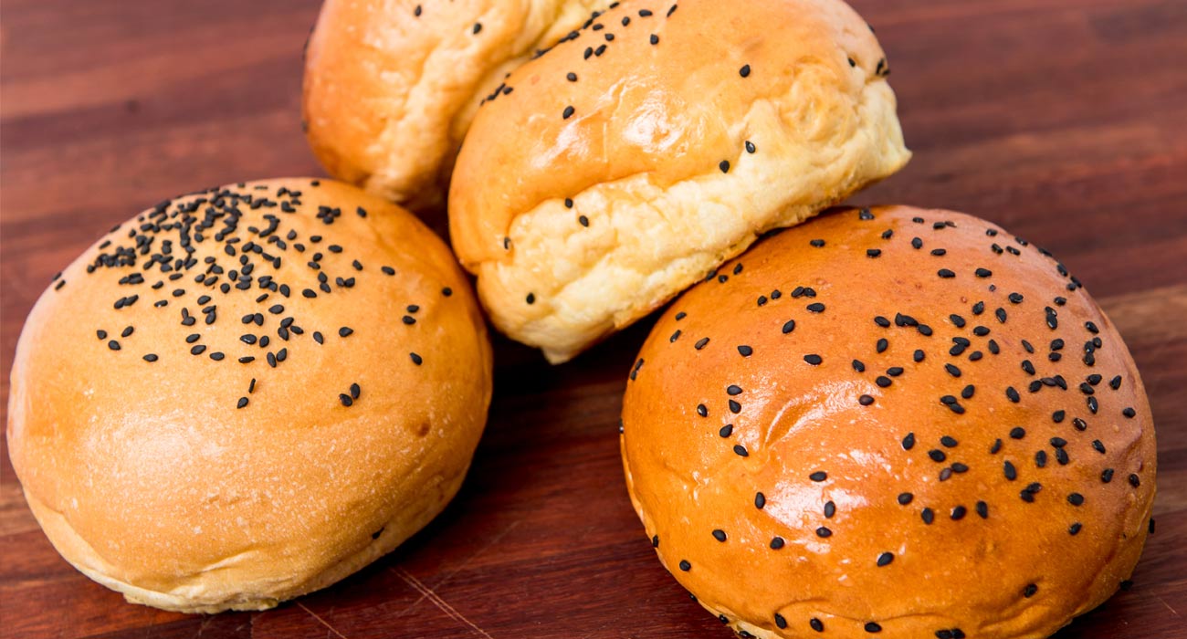 Closed-up of the 4 burger buns with sesame placed on top of the buns.